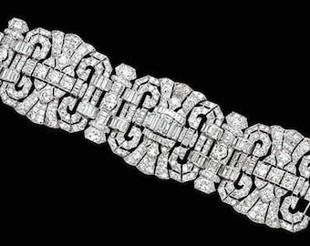 May include: A dazzling, Art Deco-style bracelet. The jewelry piece features an intricate design of sparkling, clear gemstones set in a geometric pattern. The bracelet is displayed against a black background.