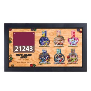 May include: A framed display featuring race medals and a maroon race bib with the number 21243. The medals have colorful cartoon character designs. The text "RACE NAME HERE" and "2026 • 48.6 Miles" are also visible.