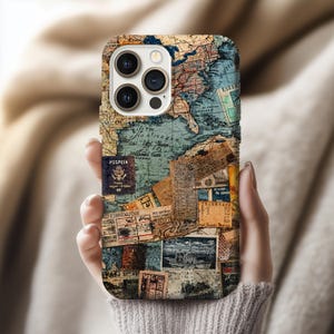 May include: A phone case featuring a vintage map design with passport stamps and travel ephemera. The case has a collage of old maps, tickets, and documents in shades of blue, brown, and beige. The phone case is held by a person.