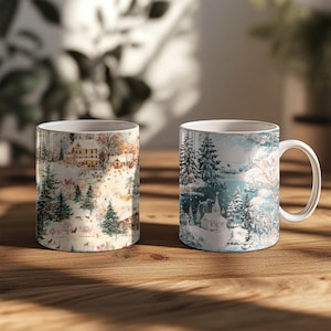 Puede incluir: Dos tazas de cer&aacute;mica blanca con dise&ntilde;os de paisajes invernales. Una taza presenta una escena de pueblo con &aacute;rboles y una casa, mientras que la otra representa un bosque nevado con una iglesia. Ambas tazas tienen asas blancas y est&aacute;n sobre una superficie de madera.