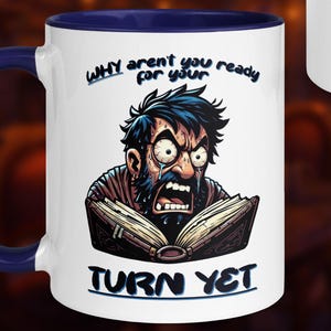 Peut inclure: Mug en céramique blanche avec une anse et un intérieur bleus. La tasse présente une illustration de dessin animé d'un homme à l'expression fâchée lisant un livre. Le texte sur la tasse se lit "WHY aren't you ready for your TURN YET".