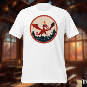 Könnte beinhalten: Weißes T-Shirt mit einem roten Drachen-Motiv in einem Kreis. Der Drache spuckt Feuer und hat schwarze Flügel. Der Kreis hat einen blauen und roten Rand.