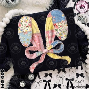 Peut inclure: Un sweat-shirt noir avec un motif d'oreilles de lapin en patchwork aux motifs floraux et pastel. Les oreilles sont reliées par un nœud en ruban rose. L'image contient le texte "Minhstorevn Digital File".