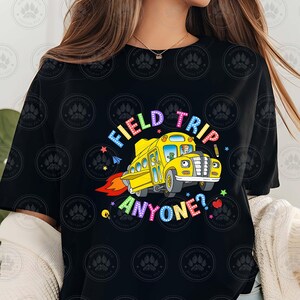 May include: Black t-shirt featuring a yellow school bus graphic and the text "Field Trip Anyone?" in rainbow colours.
