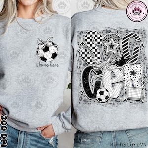 Puede incluir: Una sudadera gris con un dise&ntilde;o en blanco y negro que presenta una pelota de f&uacute;tbol, una estrella y la palabra "Soccer". El dise&ntilde;o est&aacute; sobre un fondo de estampado de leopardo gris y blanco. La sudadera tiene un dise&ntilde;o de pelota de f&uacute;tbol en blanco y negro en la parte delantera con el texto "Name here".