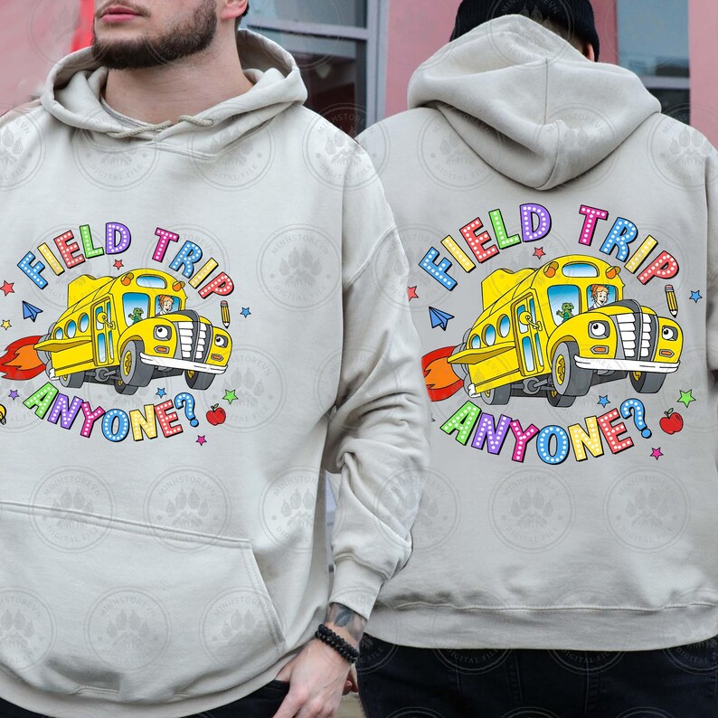May include: A light grey hoodie featuring a yellow school bus graphic and the text "Field Trip Anyone?" in rainbow lettering. The hoodie has a hood and a pouch pocket.
