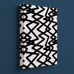 Könnte beinhalten: Ein rechteckiges Leinwandkunstwerk mit einem schwarz-weißen geometrischen Muster. Das Design besteht aus miteinander verbundenen Zickzacklinien und Rauten auf weißem Hintergrund. Das Kunstwerk ist auf einem Holzrahmen montiert.