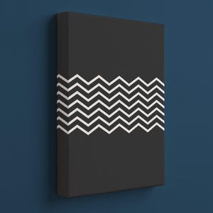Könnte beinhalten: Schwarze Leinwandkunst mit einem weißen Zickzackmuster. Das Kunstwerk ist rechteckig und an der Wand befestigt. Der Hintergrund ist dunkelblau.