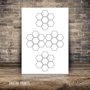 May include: A white print featuring three clusters of black honeycomb shapes. The phrase "DIGITAL PRINTS" is printed in a sans-serif font at the bottom of the image. The image is displayed against a brick wall and wooden surface.