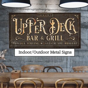 May include: A rectangular metal sign with the text "UPPER DECK BAR & GRILL" in a vintage style. The sign is brown with cream-coloured lettering and the text "PROUDLY SERVING WHATEVER YOU BROUGHT". The sign is labelled "Indoor/Outdoor Metal Signs".