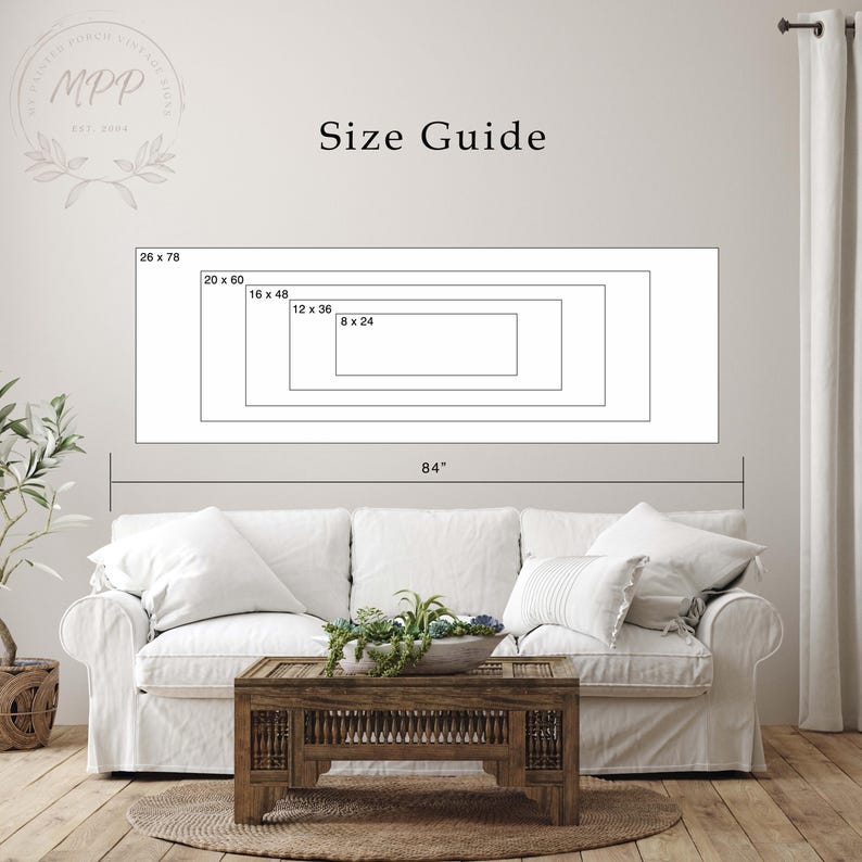 a living room with a white sofa, a wooden coffee table, and a potted plant. Above the sofa, there is a large size guide that provides dimensions for the sofa in inches.