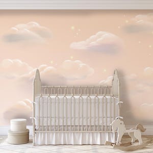 May include: A white crib with a white canopy and a white rocking horse in front of a pink wall with white clouds and gold stars.