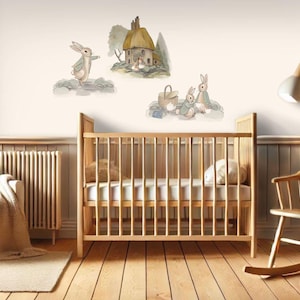 May include: A nursery room with a wooden cot, a rocking chair, and a plush armchair. The walls are decorated with a set of three wall decals featuring Peter Rabbit and his friends.