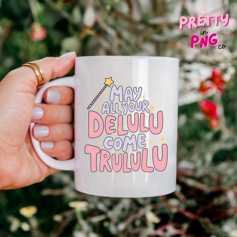 Pode incluir: Caneca de cer&acirc;mica branca com um design rosa e roxo que diz "May all your Delulu come Trululu" com um gr&aacute;fico de estrela amarela e varinha.