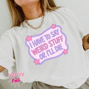 May include: White t-shirt with a graphic that reads "I HAVE TO SAY WEIRD STUFF OR I'LL DIE" in pink and purple. The text is inside a light purple banner with pink stars. The shirt also has the text "PRETTY in PNG co." in pink.