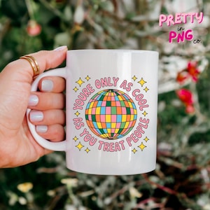 May include: White ceramic mug with a colorful disco ball graphic and the text "YOU'RE ONLY AS COOL AS YOU TREAT PEOPLE". The mug also has the text "PRETTY in PNG co." in the upper right corner.