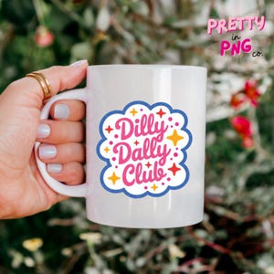 May include: A white ceramic mug featuring a blue scalloped border graphic with the pink text Dilly Dally Club. The design is accented with small yellow and red star shapes scattered around the lettering on the front of the mug.