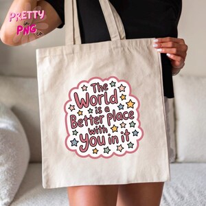 Peut inclure: Sac fourre-tout beige avec le texte "The World is a Better Place with You in it" dans un design rose et blanc. Le texte est entour&eacute; d'&eacute;toiles color&eacute;es. Le sac a deux poign&eacute;es.