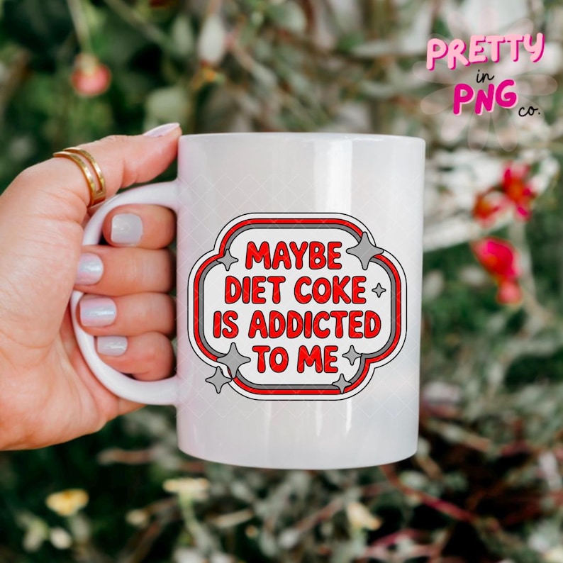 May include: White ceramic mug with the text "MAYBE DIET COKE IS ADDICTED TO ME" in a red and white design. The mug has a handle and is held by a person. The mug is a standard size.