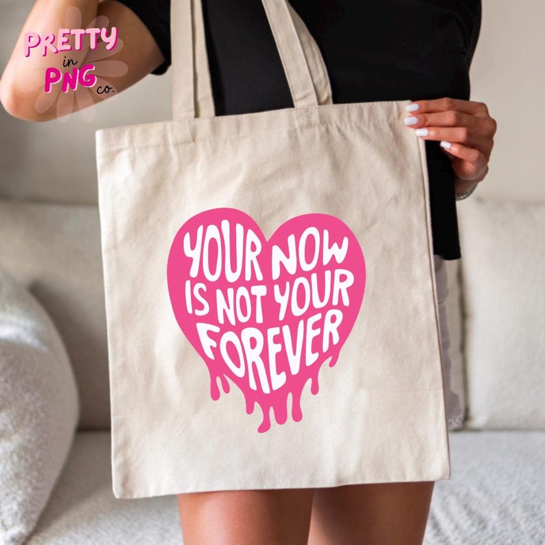 Puede incluir: Una bolsa de lona blanca con un gr&aacute;fico de coraz&oacute;n rosa que gotea que dice "Your now is not your forever".