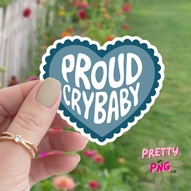 May include: A blue heart-shaped sticker with the text "PROUD CRYBABY" in white lettering.