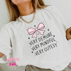 May include: White t-shirt with a pink bow and the text "Very Demure, Very Mindful, Very Cutesy".