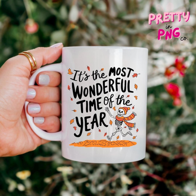 May include: White ceramic mug with a black and orange skeleton design. The mug has the text "It's the most wonderful time of the year" in black lettering.