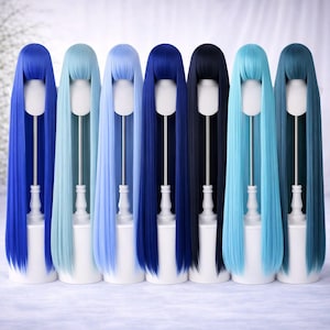May include: A collection of seven long, straight wigs in shades of blue, displayed on white mannequin heads. The colors range from light blue to deep navy and black. Each wig has a neat, straight fringe.