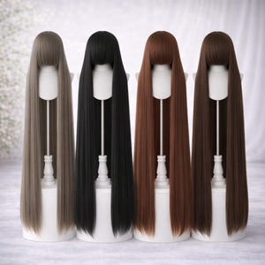 May include: Four long, straight wigs in varying shades of brown and black are displayed on white wig stands. Each wig has a blunt-cut fringe and falls well below the shoulders. The colors include light brown, black, medium brown, and dark brown.