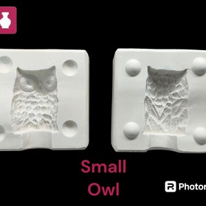 May include: Two white ceramic molds for making small owl figurines. The molds are square with rounded corners and have a raised owl design in the center.