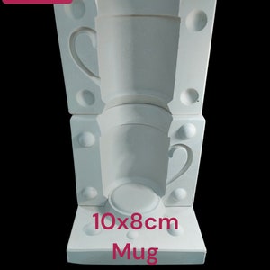 Könnte beinhalten: Weiße Keramikform zum Herstellen von Tassen. Die Form ist 10x8cm groß und für die Herstellung von zwei Tassen ausgelegt.