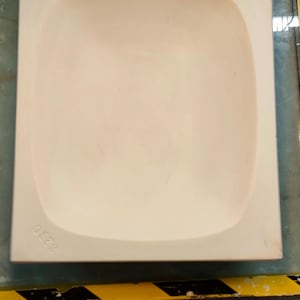 May include: A white ceramic mould with a rounded, slightly concave interior. The mould is square-shaped and has a smooth, matte finish. The text "6223" is visible on the bottom of the mould.