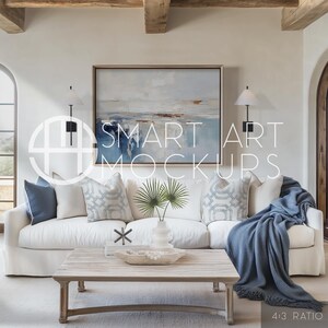 Coastal Beach Living Room Art Mockup: This beach inspired living space with a white sofa, rustic table, and blank frame smart objects offers the chance to create an ocean-themed or seascape product to sell your art in  a breezy beach house interior.