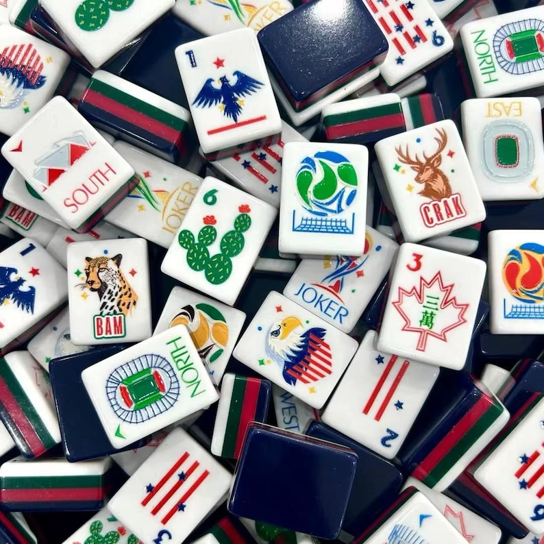 K&ouml;nnte beinhalten: Eine Sammlung wei&szlig;er Mahjong-Spielsteine mit verschiedenen bunten Illustrationen, darunter ein Gepard, ein Hirsch, ein Kaktus, ein Adler, ein Ahornblatt und Stadiongrafiken. Einige Steine zeigen den Text JOKER, SOUTH, NORTH oder CRAK in Rot oder Blau.