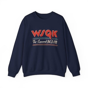 May include: Navy blue sweatshirt with the text "WSQK The Squawk 94.5 FM" in red and white. The sweatshirt has a crew neck and long sleeves. The text is in a retro style.