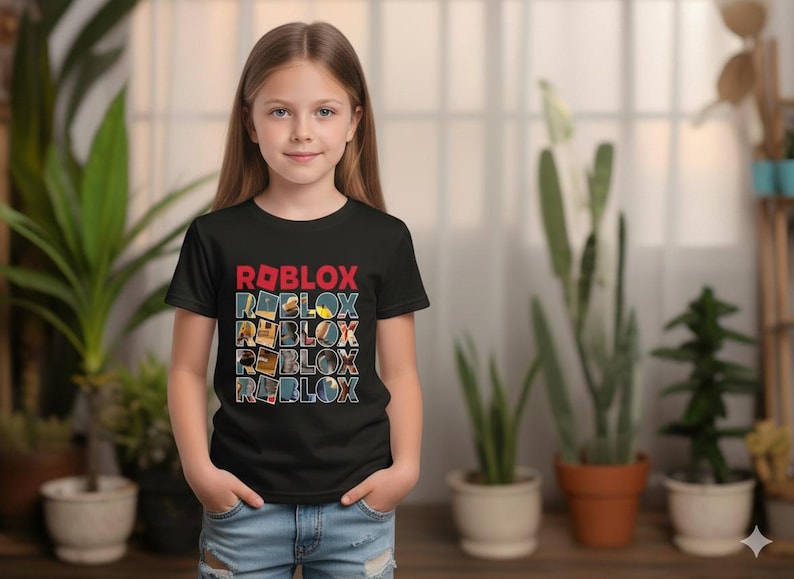 May include: A black t-shirt with the word "ROBLOX" in red and blue block letters. The shirt is being worn by a young person, and the background includes plants and a window.