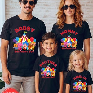 May include: Black t-shirts with colorful graphics and text for a family. The shirts read "Daddy of the Birthday Boy," "Mommy of the Birthday Boy," "Brother of the Birthday Boy," and "Amelia the Birthday Girl."