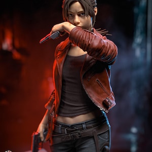 May include: A detailed figurine of a person with brown hair wearing a dark brown tank top, a red leather jacket, and dark pants with a belt and holster. The figure holds a black handgun near the face and another in the right hand, with H3LL CREATOR text.