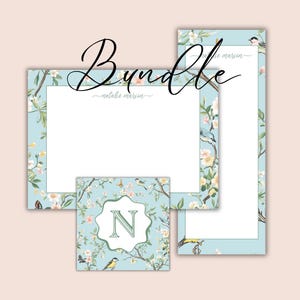 May include: A stationery bundle featuring a light blue floral design with birds and the letter "N". The bundle includes a notepad, a long notepad, and a square coaster. The word "Bundle" is written in cursive.
