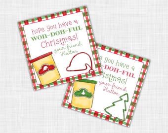 Puede incluir: Dos etiquetas de regalo navideñas con un borde a cuadros rojo y verde. Cada etiqueta presenta una ilustración de un recipiente de plastilina amarillo y el texto "hope you have a WON-DOH-FUL Christmas!" y "your friend, Hatton."