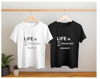 Peut inclure: Un t-shirt blanc et un t-shirt noir, tous deux arborant le texte imprimé "LIFE = Σ(PROBLEMS) Solve for X!" dans une couleur contrastante. Chaque t-shirt possède des manches courtes et un col rond, suspendus côte à côte sur des cintres.