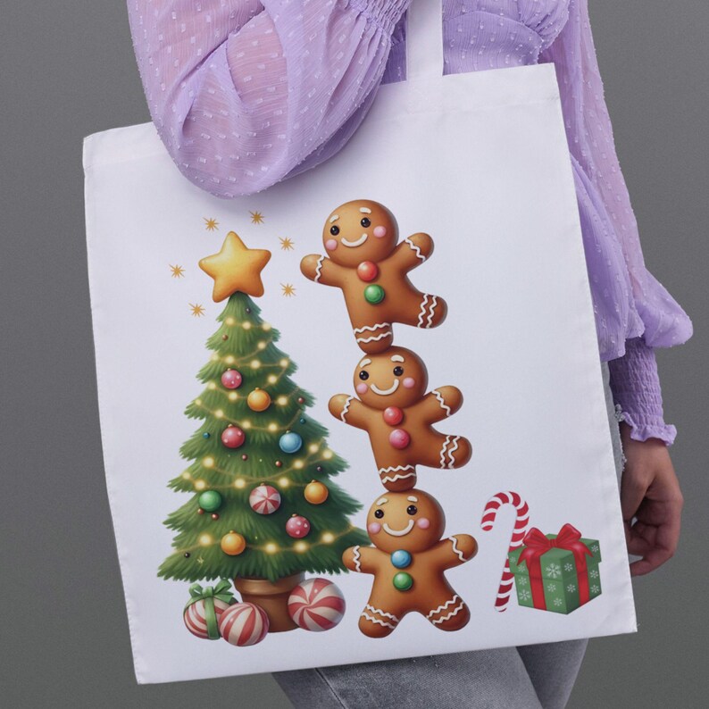 May include: White tote bag featuring a Christmas design. The design includes a decorated Christmas tree, three gingerbread men stacked on top of each other, a candy cane, and a wrapped gift. The bag is held by a person wearing a purple shirt.