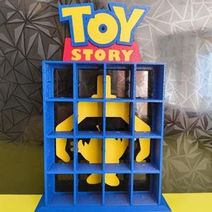 May include: A blue and yellow Toy Story themed display stand with 16 compartments. The stand features the Toy Story logo and a silhouette of Woody.