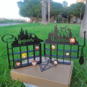 May include: Black display stand with two sections, one labelled "Hogwarts" and the other "Quidditch". Each section has nine compartments for displaying small figurines. The stand is made of wood and has a black finish.