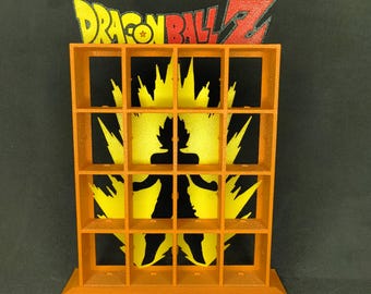 May include: An orange, grid-style display shelf featuring the "Dragon Ball Z" logo in yellow and red. The shelf has a black and yellow silhouette design of a character. The shelf is made of a solid material.