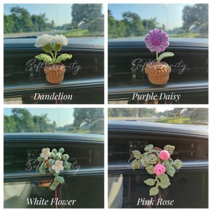 以下が含まれることがあります： 車の通気口用の、かぎ針編みの花の装飾4つ。花には、白いタンポポ、紫色のデイジー、白い花、ピンクのバラがあります。各花は茶色のポットに入っています。「Soft Serenity」の文字が各画像にあり、花の名前も記載されています。