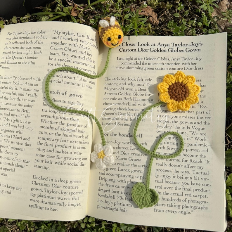 Puede incluir: Marcap&aacute;ginas de ganchillo con una abeja, un girasol y una margarita. La abeja amarilla tiene rayas negras y una cara sonriente. El girasol tiene p&eacute;talos amarillos y un centro marr&oacute;n. La margarita es blanca.