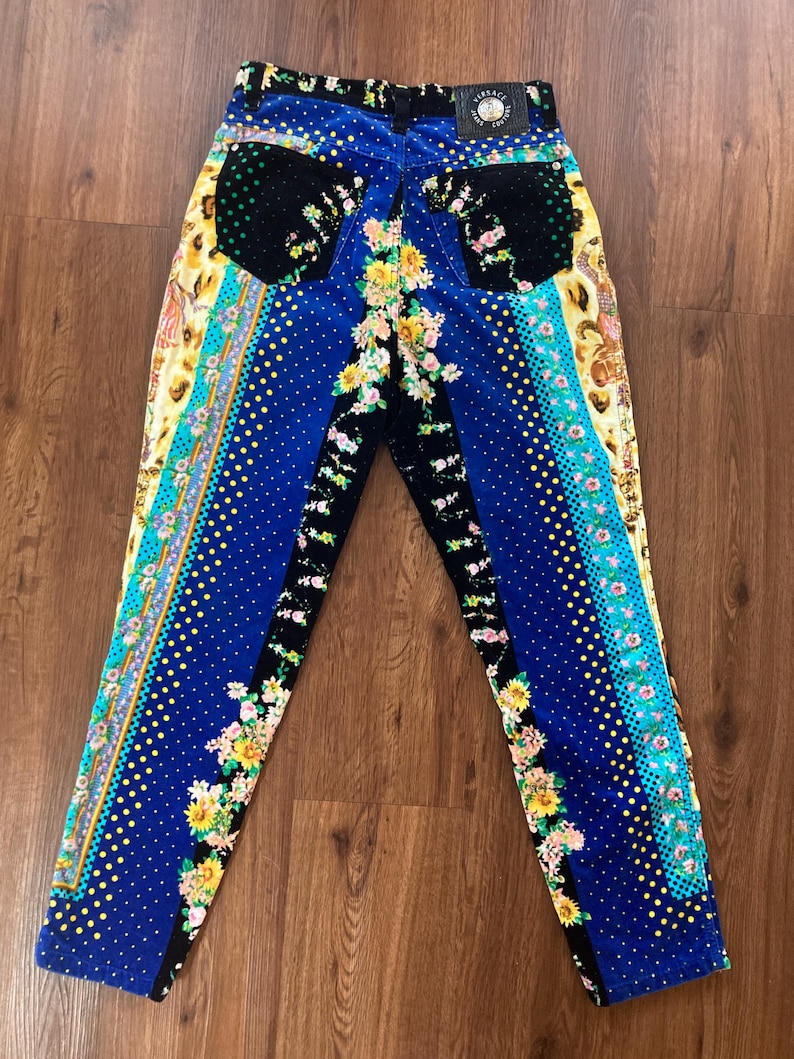 Peut inclure: Jean &agrave; motifs bleus, noirs et jaunes avec des motifs floraux et &agrave; pois. Le jean a une ceinture noire avec un patch en cuir. Le jean a une coupe droite.