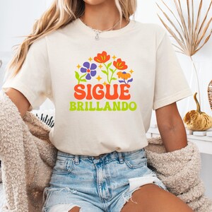 Sigue Brillando Latina Shirt: Floral Good Energy Tee