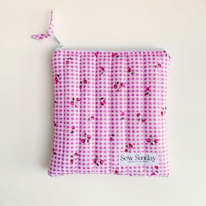 May include: Pink quilted zippered pouch with a white gingham pattern and small pink floral print. The pouch has a white label that says "Sew Sunday Handmade in Melbourne".